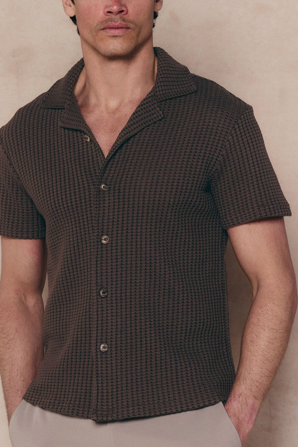 Man wearing a brown Marcos patterned waffle short sleeve shirt with an open collar and button-through front.