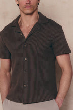 Man wearing a brown Marcos patterned waffle short sleeve shirt with an open collar and button-through front.