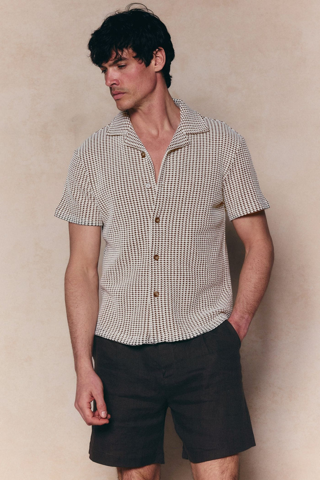 Marcos white/brown patterned waffle short sleeve shirt with open collar and brown buttons, paired with dark shorts.