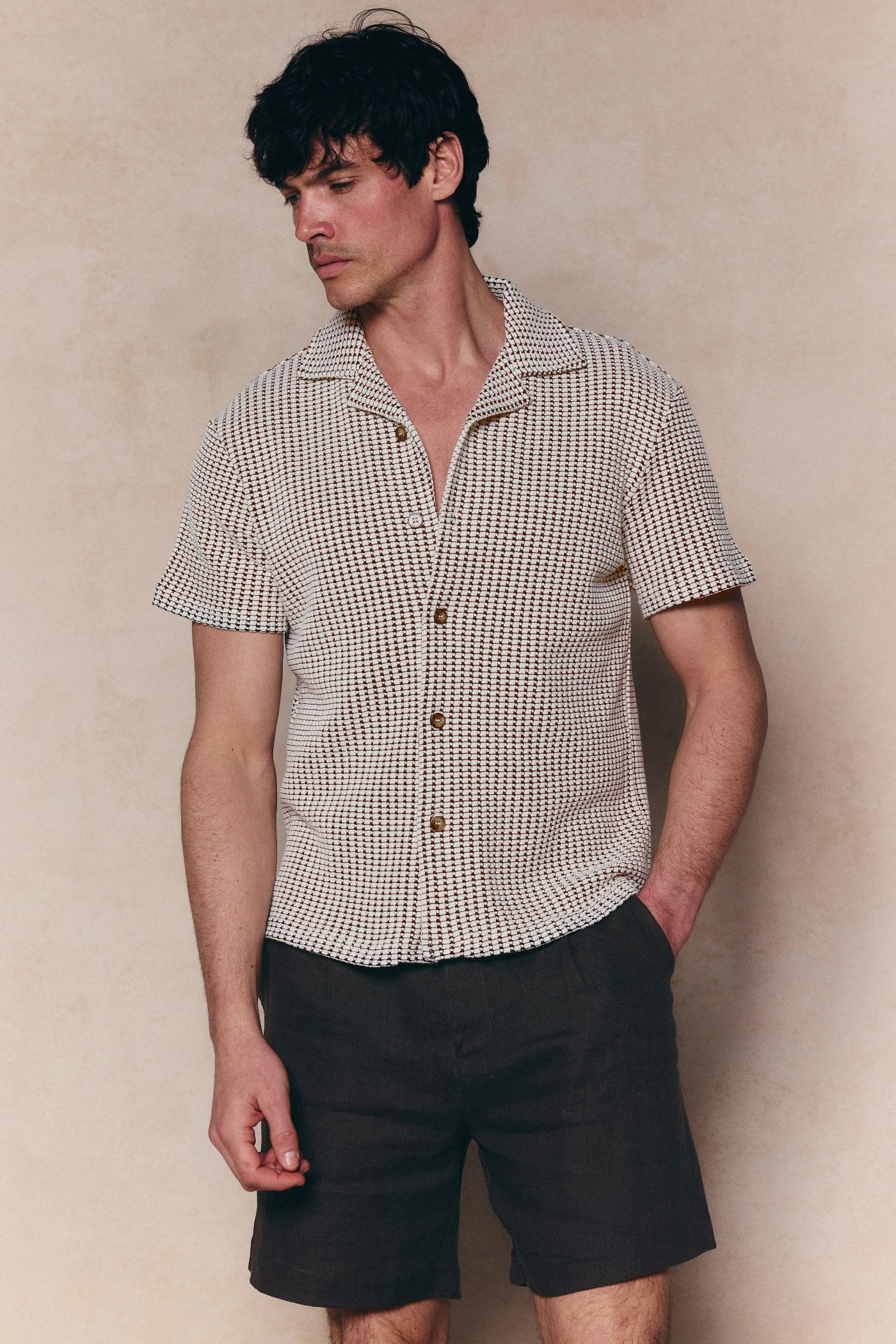 Marcos white/brown patterned waffle short sleeve shirt with open collar and brown buttons, paired with dark shorts.
