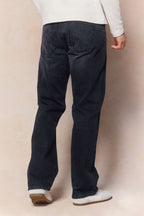 Man wearing black wash Mason relaxed fit jeans made from 14oz cotton denim, featuring a leather back patch.