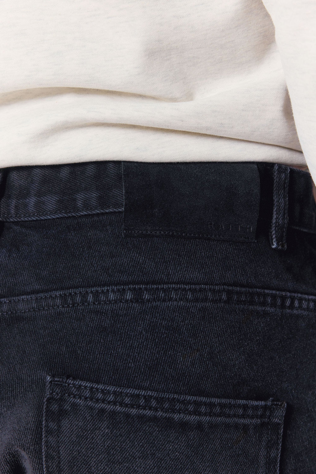 Close-up of Mason Relaxed Fit Jeans in black wash, showing the dyed-to-match leather back patch.