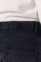 Close-up of Mason Relaxed Fit Jeans in black wash, showing the dyed-to-match leather back patch.