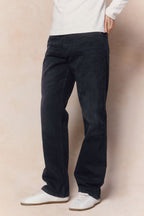Mason relaxed fit jeans in black wash 100% cotton denim, worn with white sneakers.