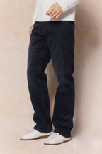 Mason relaxed fit black wash jeans in 100% cotton denim, worn with a white long-sleeve shirt and sneakers.
