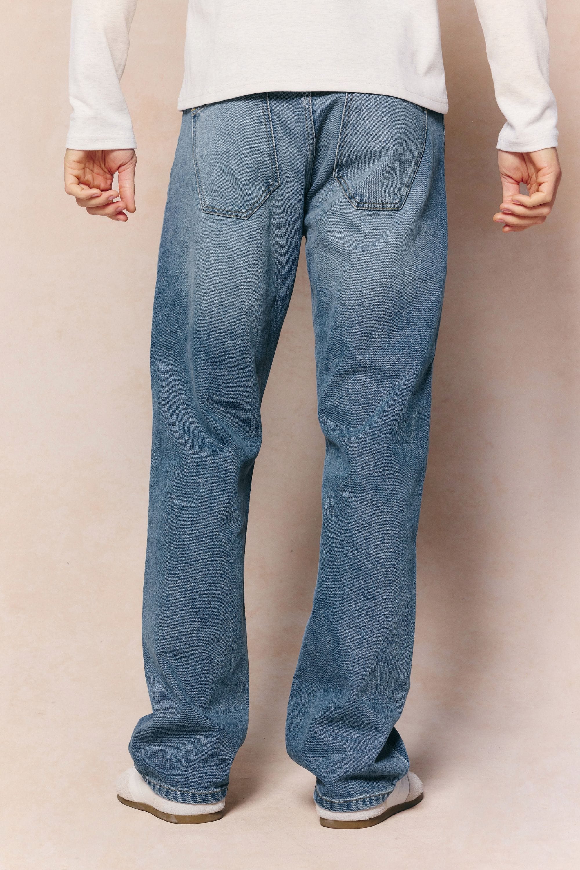 Mason Relaxed Fit Jeans in midwash indigo 100% cotton denim, shown from behind with tan leather patch.