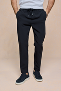 Black Mateo Tapered Trouser with elasticated drawcord waistband, worn by a person with hands in pockets.
