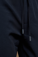 Close-up of dark navy Mateo Tapered Trouser with elasticated drawcord waistband and silver aglets.
