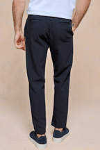 Man wearing dark navy Mateo Tapered Trousers with an elasticated drawcord waistband and back pockets.