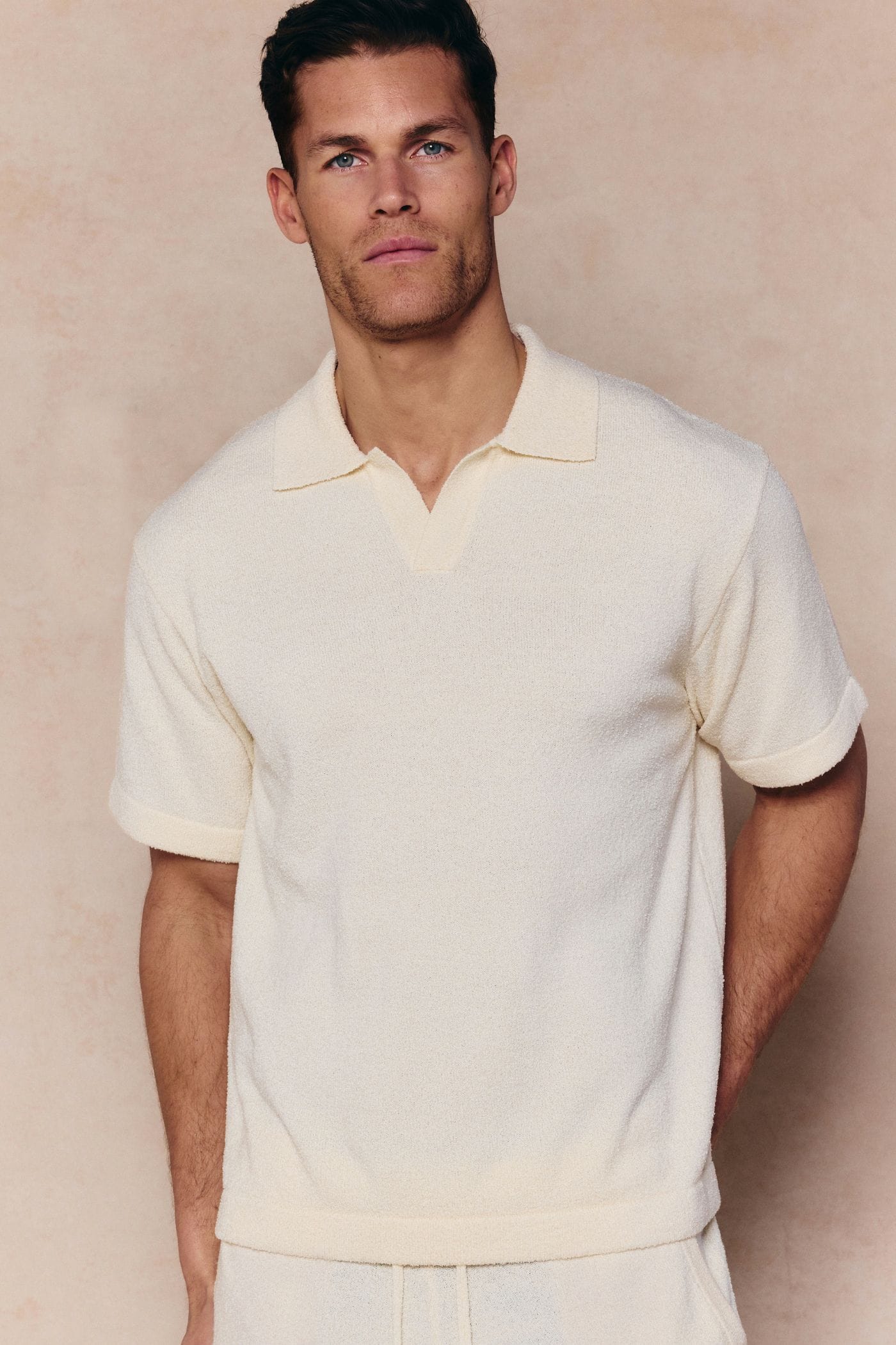 Man wearing an ecru Miguel Boucle Polo Shirt with a clean open collar and relaxed fit.