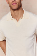 Man wearing an ecru Miguel Boucle Polo Shirt with a textured fabric and open collar.