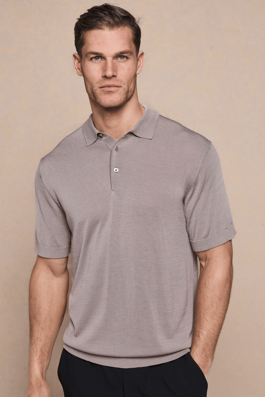 Man wearing a tailored Pablo Half Placket Short Sleeve Knitted Polo in sand with ribbed sleeves and hem.