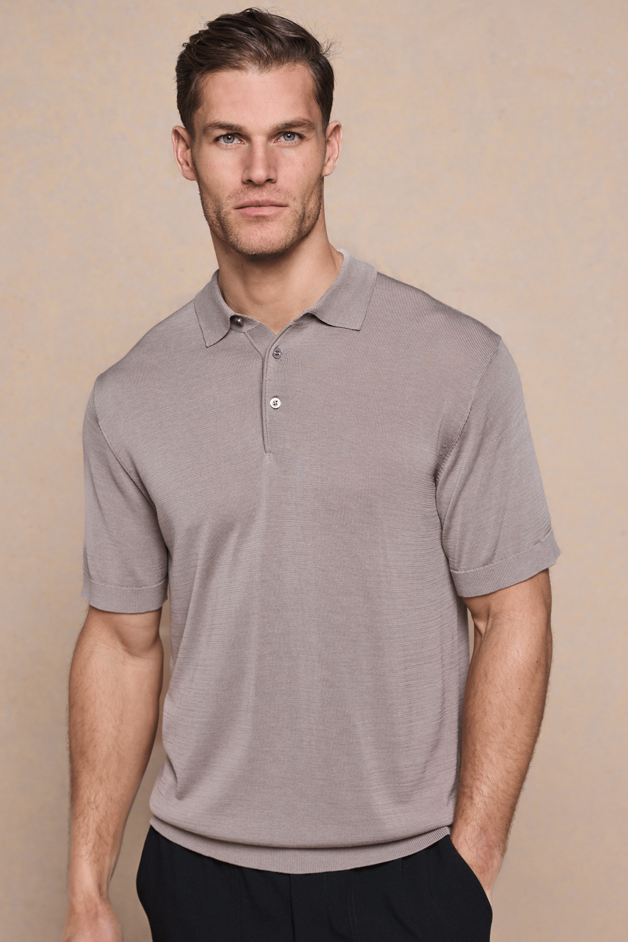 Man wearing a tailored Pablo Half Placket Short Sleeve Knitted Polo in sand with ribbed sleeves and hem.