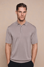 Man wearing a tailored sand knitted polo with a half placket, ribbed sleeves, and hem.