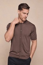 Man in a tailored brown knitted short-sleeve shirt with a full button-through front and ribbed details.