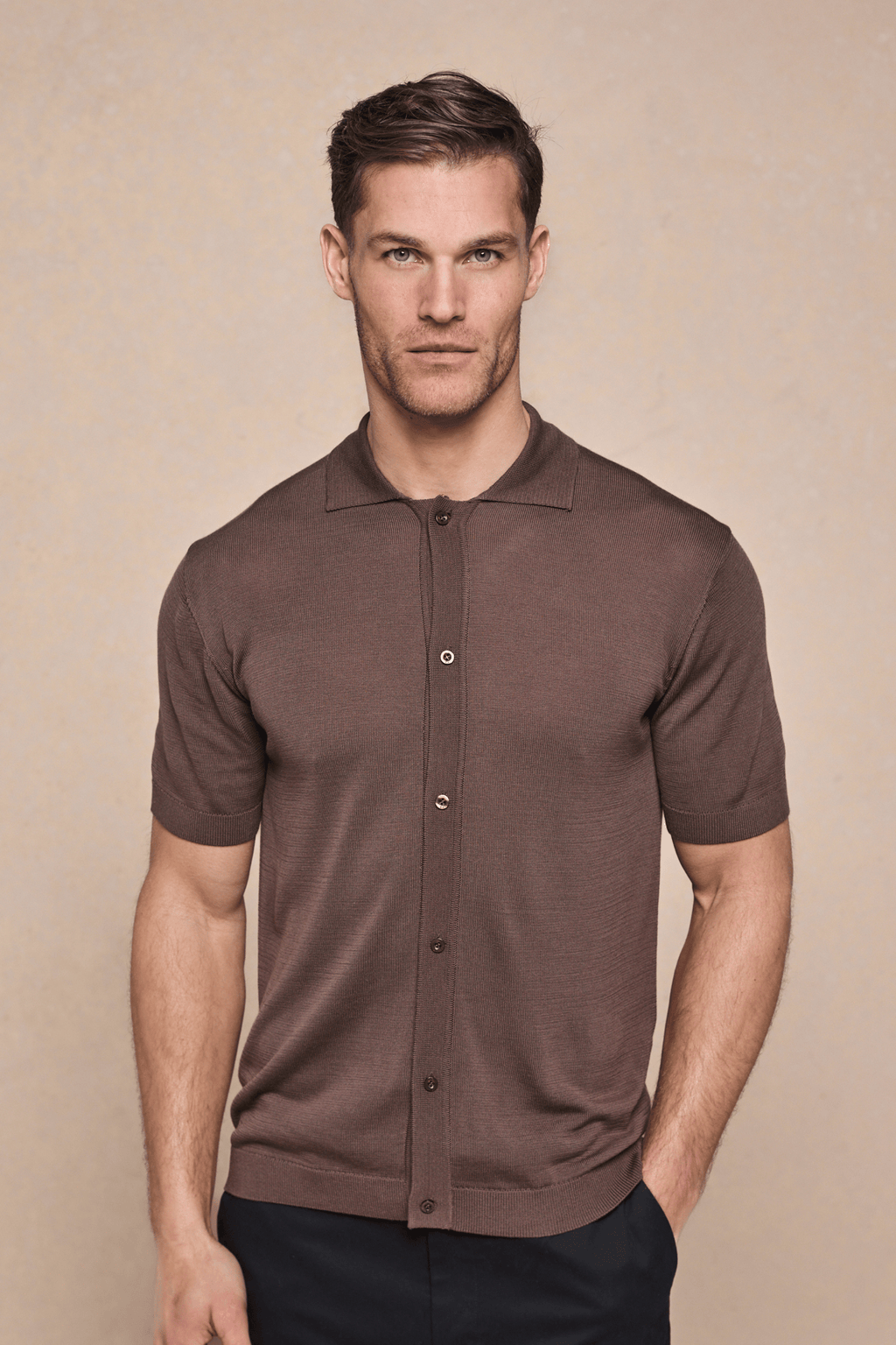 Man wearing a brown Pedro button-through short sleeve knitted shirt with ribbed sleeves and hem.