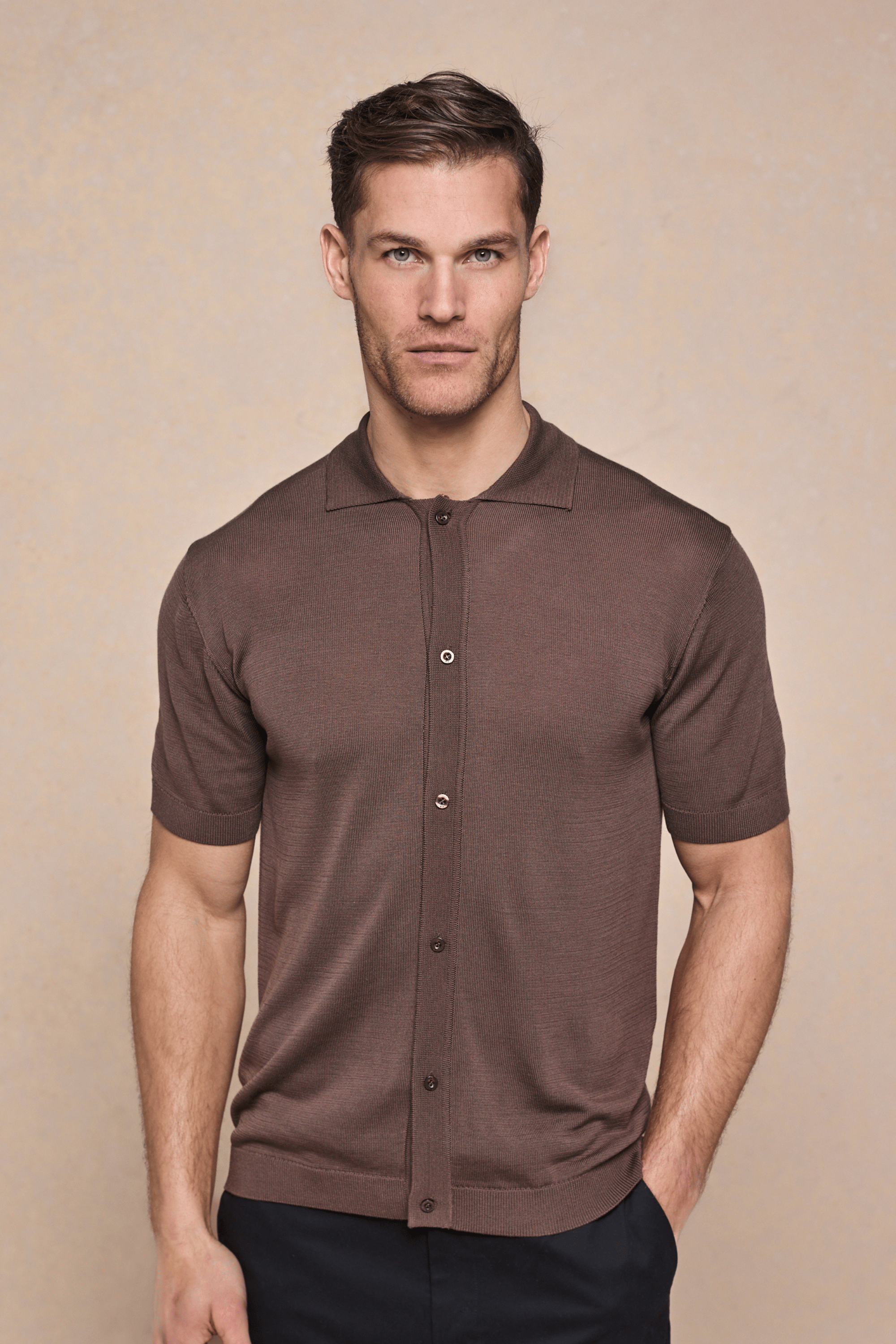 Man wearing a brown Pedro button-through short sleeve knitted shirt with ribbed sleeves and hem.