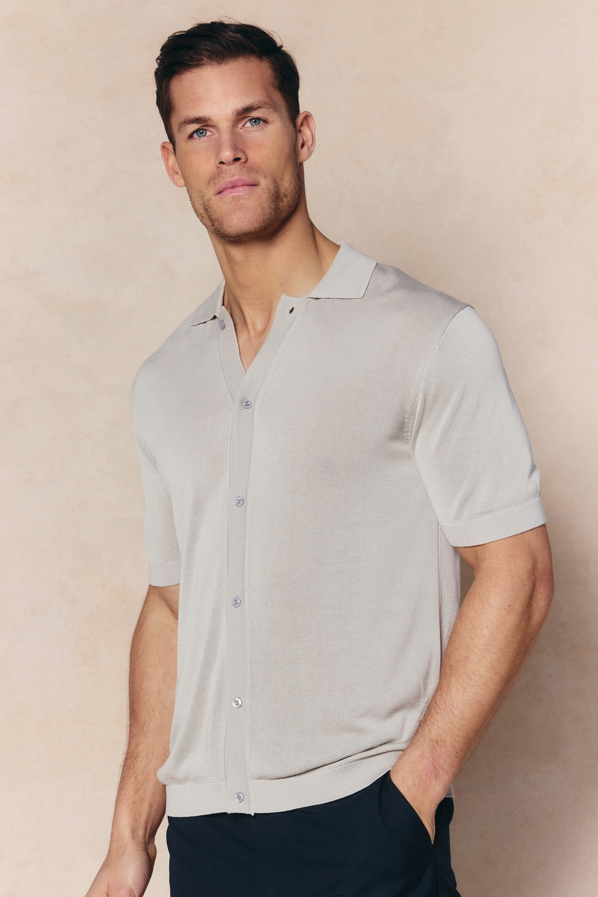 Man wearing a cream Pedro knitted short sleeve shirt with a button-through front and ribbed details.