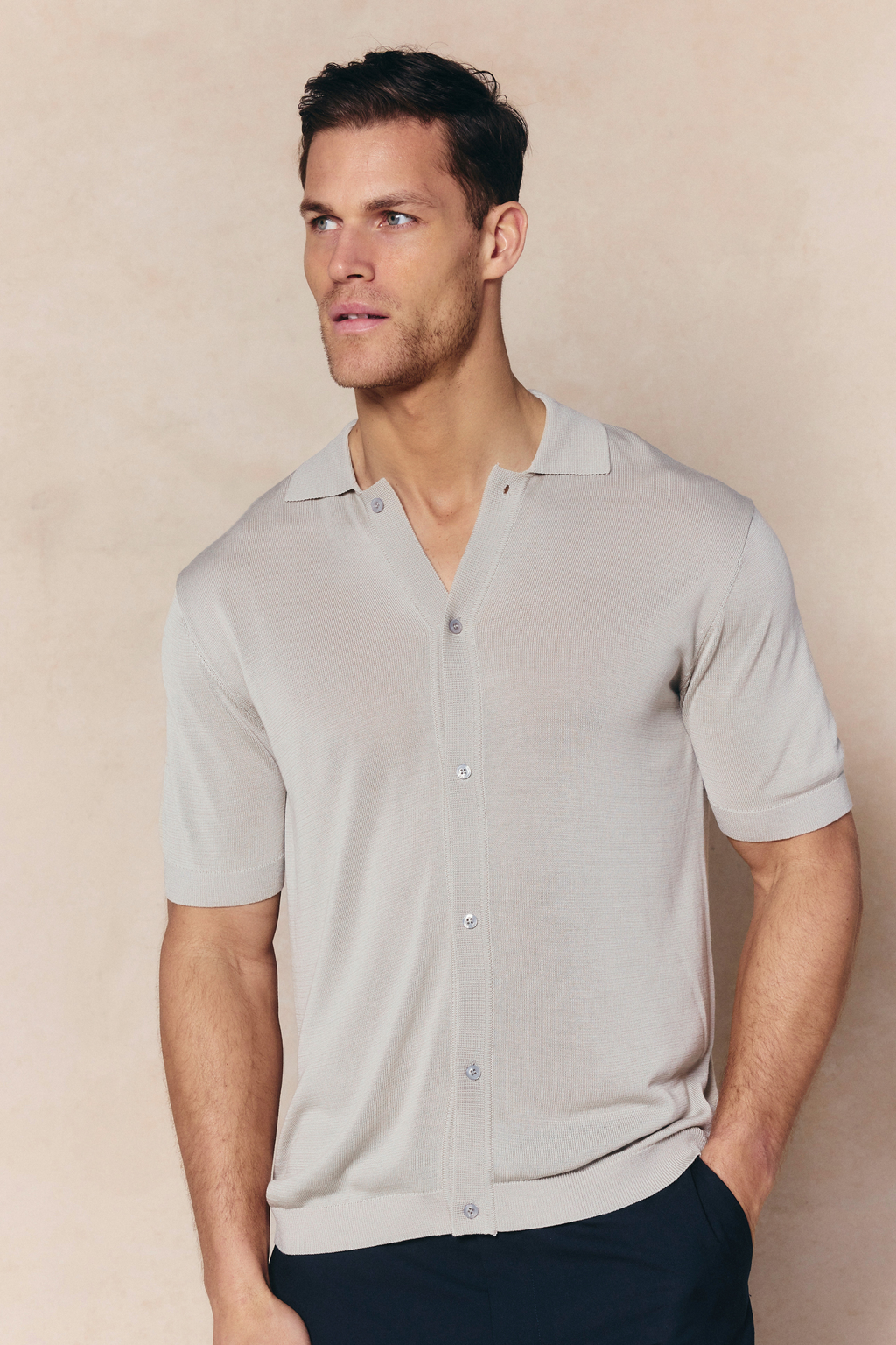 Man wearing a cream Pedro knitted short sleeve shirt with a button-through front and ribbed details.