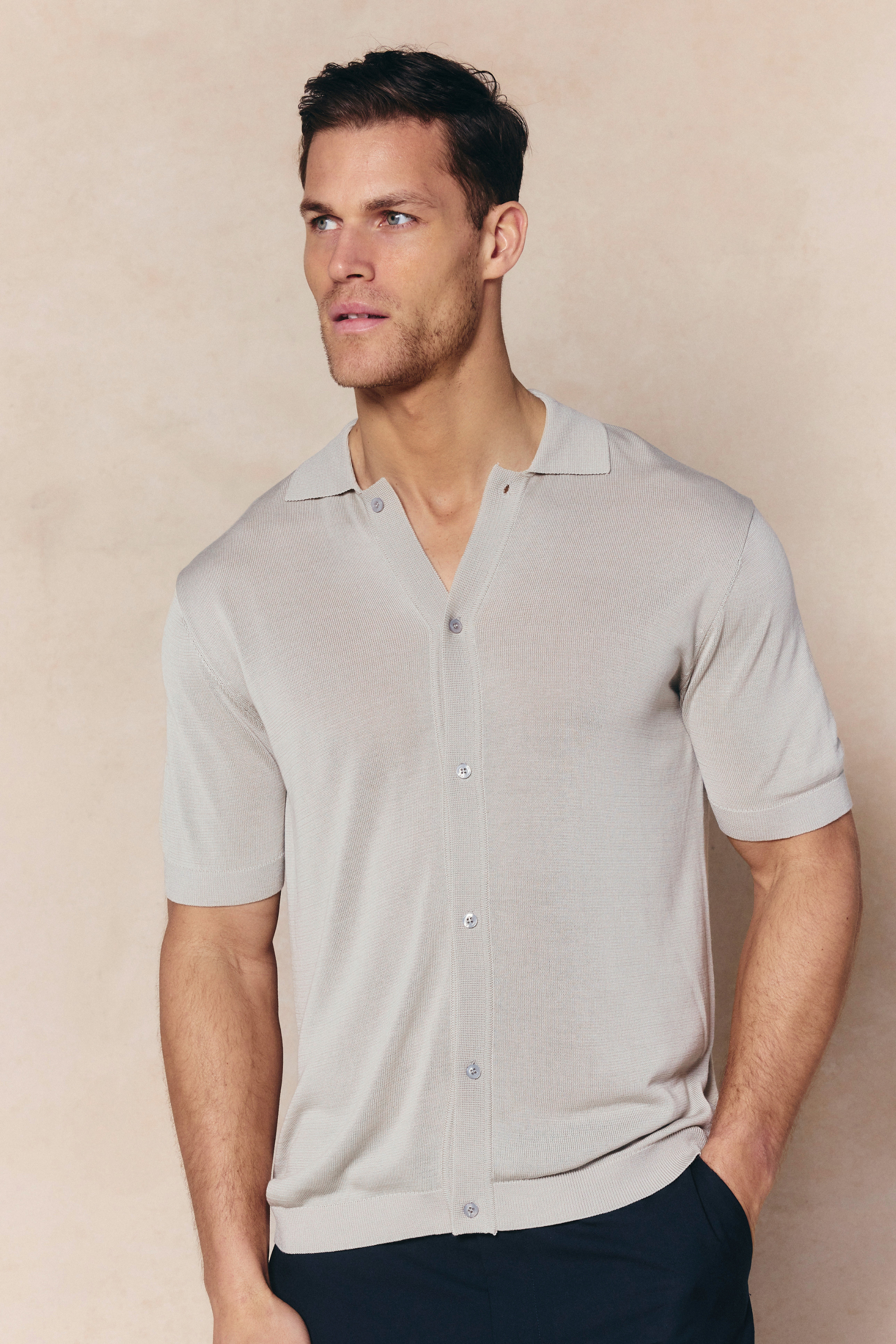 Man wearing a cream Pedro knitted short sleeve shirt with a button-through front and ribbed details.