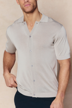Man wearing a cream Pedro knitted short sleeve shirt with a button-through front and ribbed details.