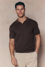 Man wearing a brown Rapha Cotton Knit Polo with an open collar, textured finish, and ribbed hems.