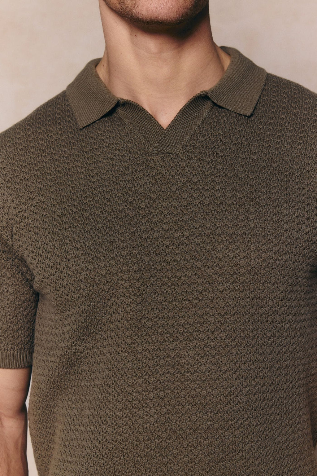 Dark olive Rapha men's cotton knit polo with open collar and textured finish.