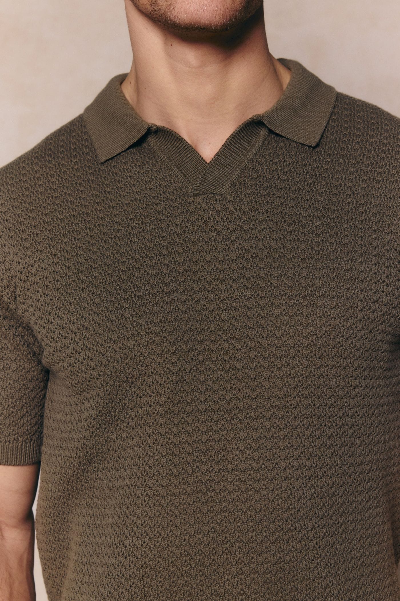 Dark olive Rapha men's cotton knit polo with open collar and textured finish.