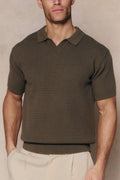 Man wearing a dark olive Rapha Cotton Knit Polo with an open collar and textured finish.