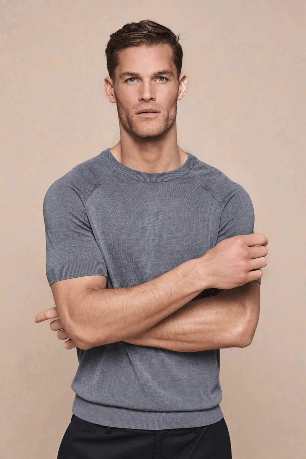 Man in a grey marl Riera Knit Crew Neck T-Shirt with ribbed details and tailored short sleeves.
