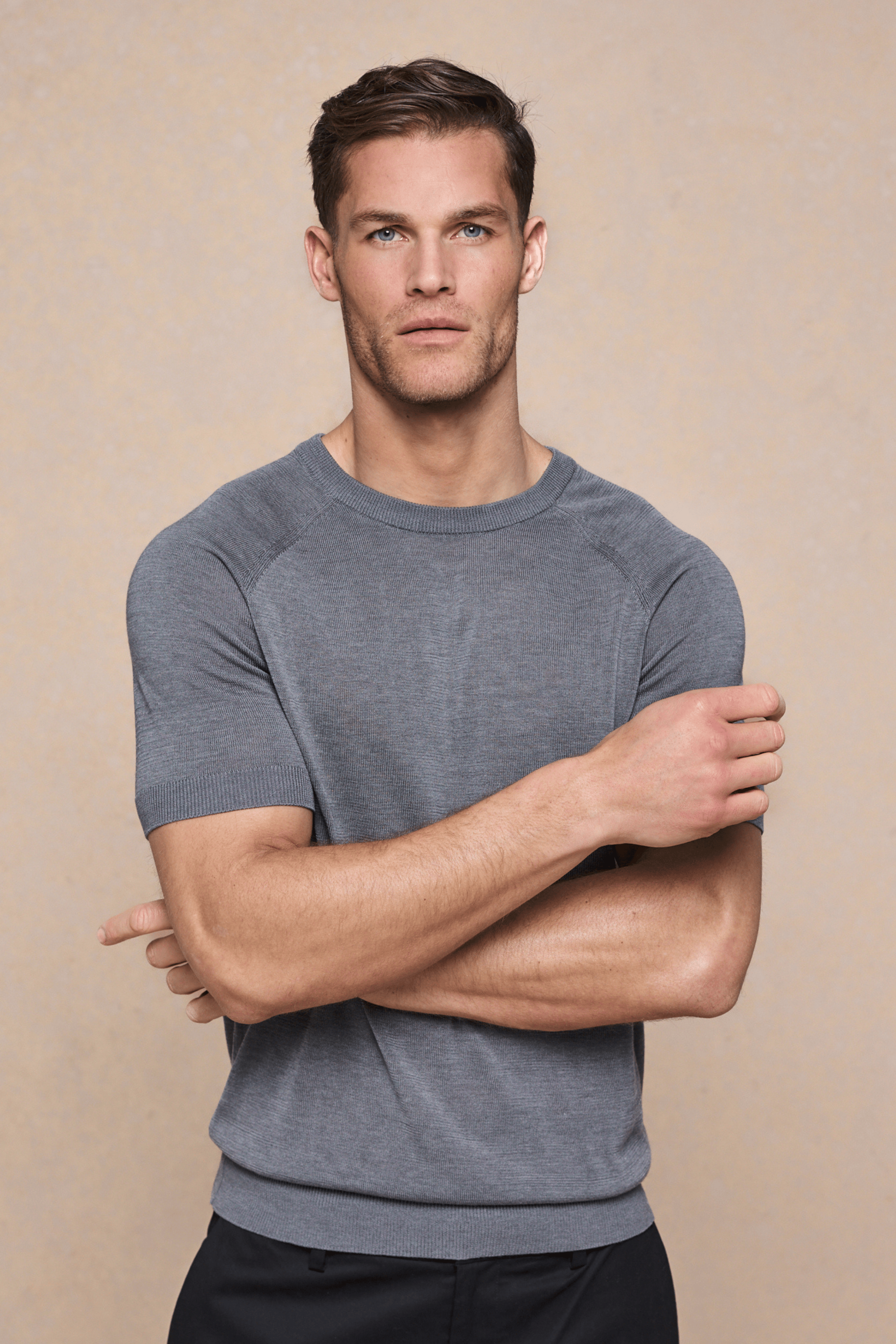 Man in a grey marl Riera Knit Crew Neck T-Shirt with ribbed details and tailored short sleeves.