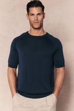 Man wearing a Midnight Blue Riera Knit Crew Neck T-Shirt with ribbed details and tailored short sleeves.