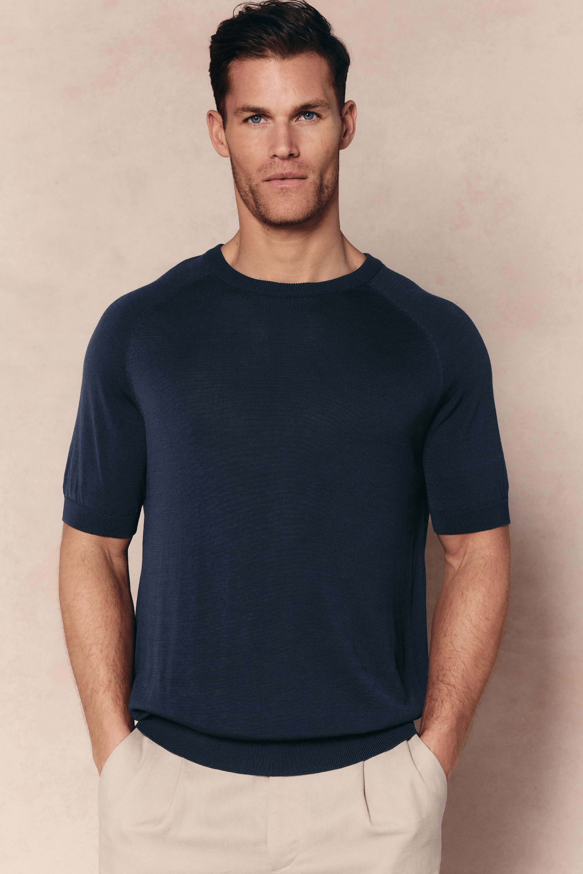 Man wearing a Midnight Blue Riera Knit Crew Neck T-Shirt with ribbed details and tailored short sleeves.