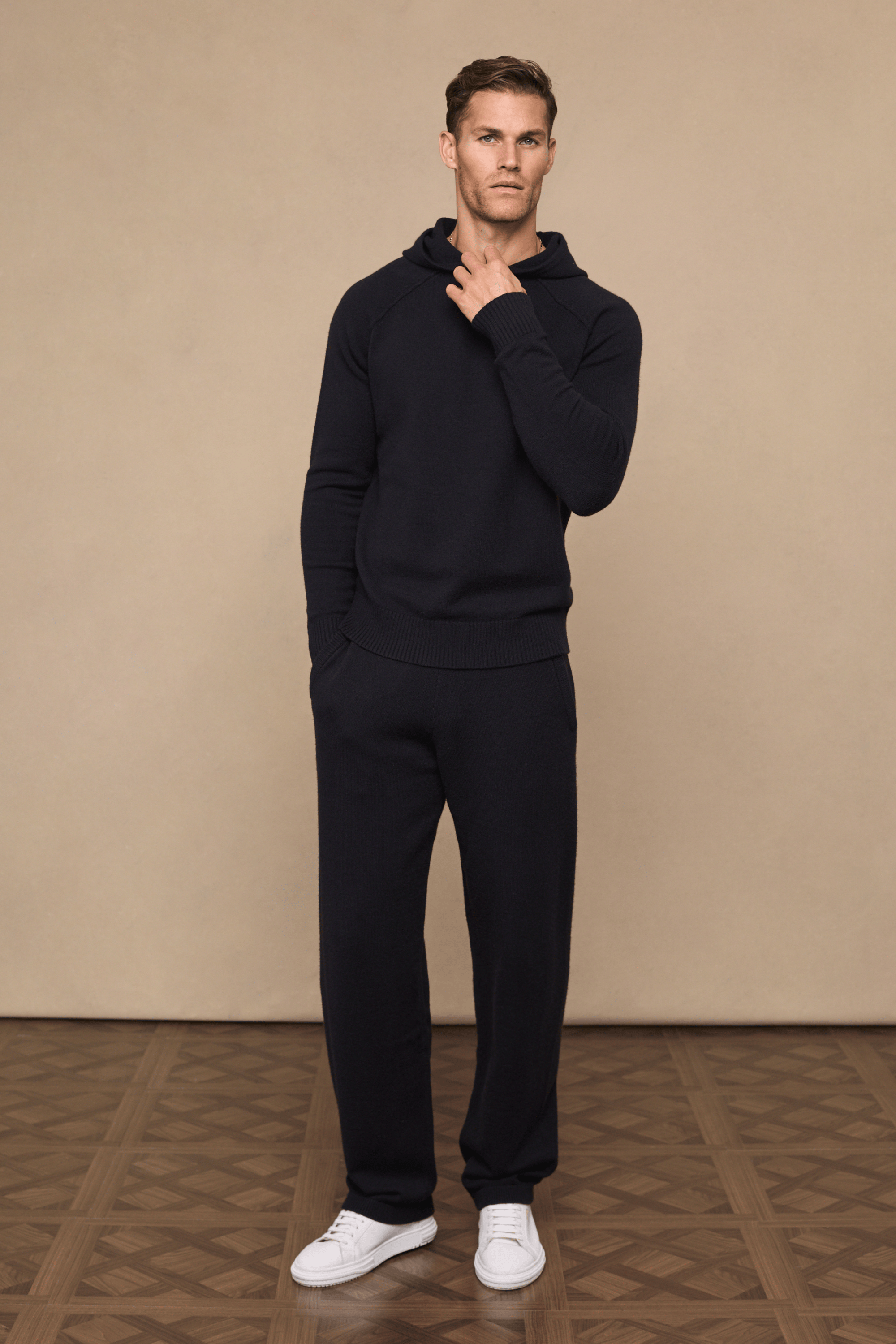 Man wearing a black knitted hoodie and matching Rowan Knitted Trousers with side pockets and drawcords.