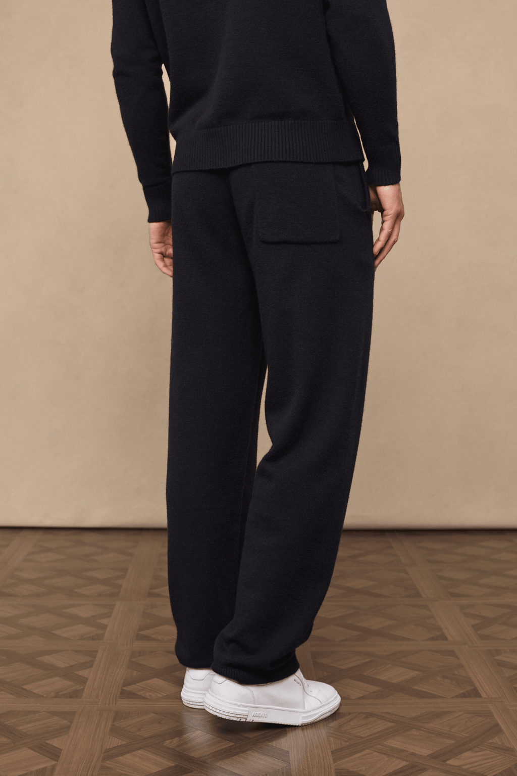 Black Rowan Knitted Trouser, ultra-soft yarn, with a back pocket, paired with white sneakers.