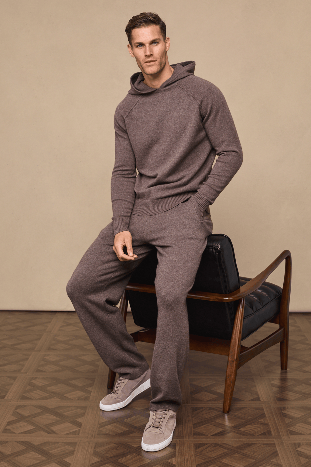 Man wearing a Rowan Knitted Trouser and Hoodie set in Brown Marl, featuring soft yarn, side pockets, and drawcords.