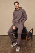 Man wearing a Rowan Knitted Trouser and Hoodie set in Brown Marl, featuring soft yarn, side pockets, and drawcords.