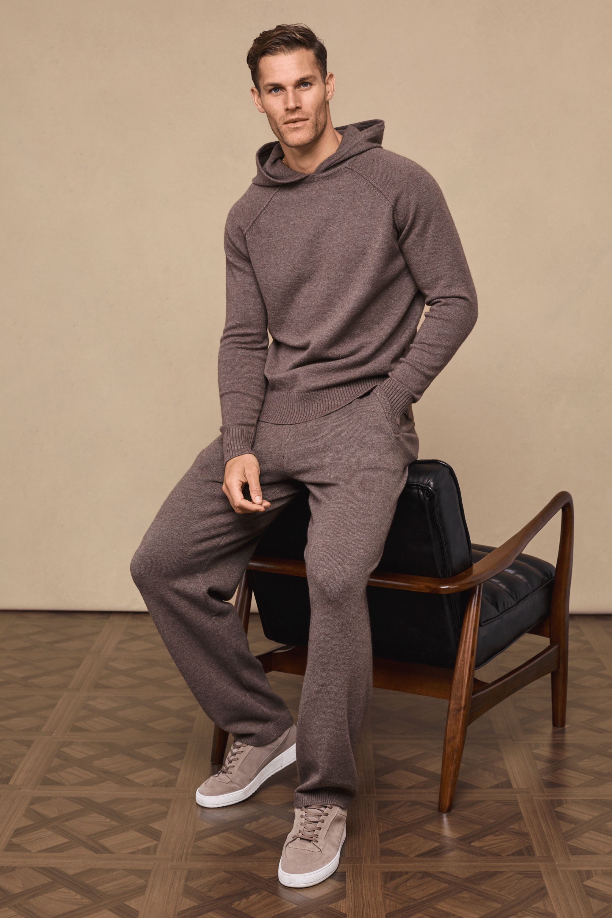 Man wearing a Rowan Knitted Trouser and Hoodie set in Brown Marl, featuring soft yarn, side pockets, and drawcords.