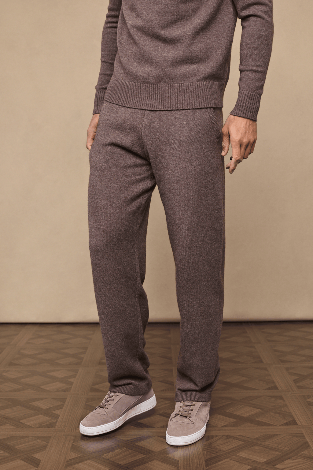 Man wearing Rowan Knitted Trouser in Brown Marl, made from ultra-soft yarn, with side pockets and drawcords.