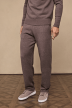 Man wearing Rowan Knitted Trouser in Brown Marl, made from ultra-soft yarn, with side pockets and drawcords.