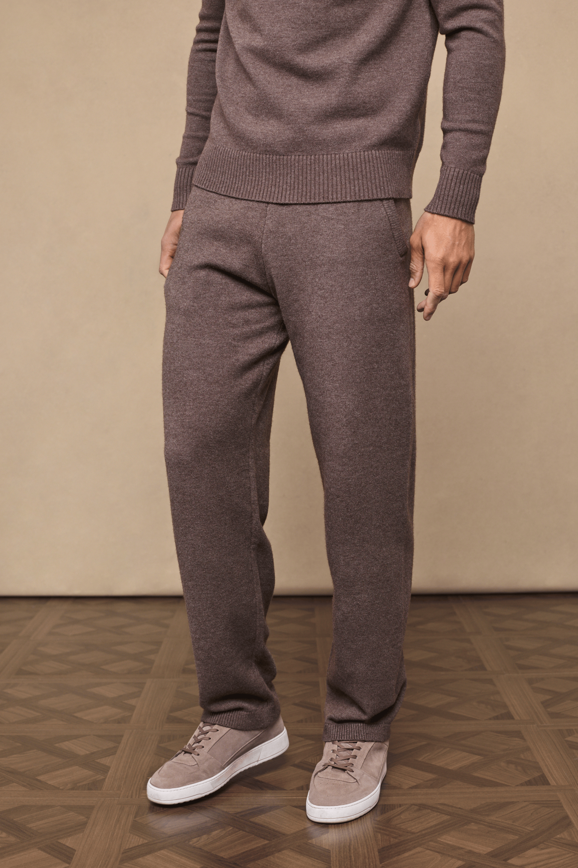 Man wearing Rowan Knitted Trouser in Brown Marl, made from ultra-soft yarn, with side pockets and drawcords.
