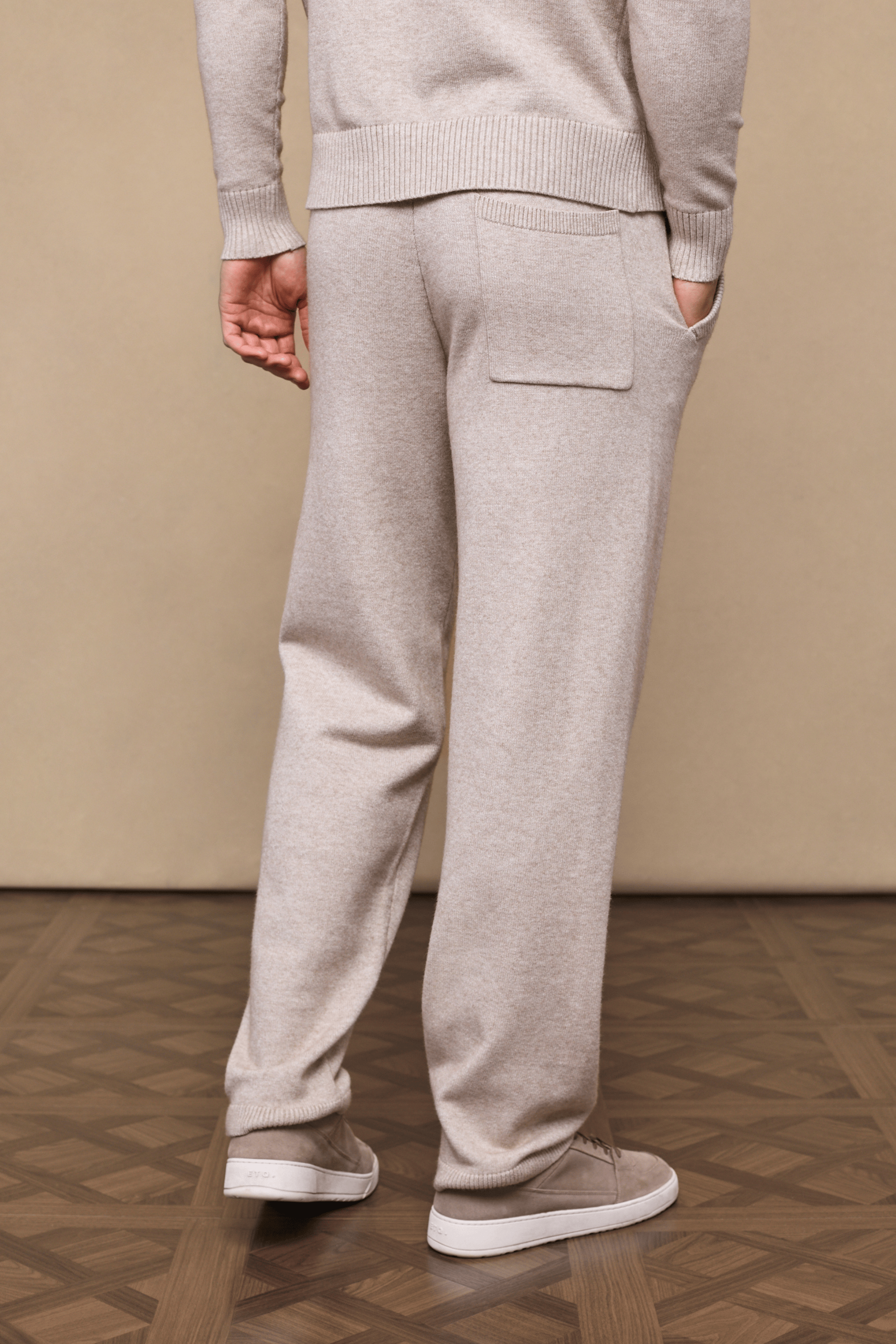 Model wearing oatmeal Rowan Knitted Trouser and matching sweater, featuring a back pocket and side entry pockets.