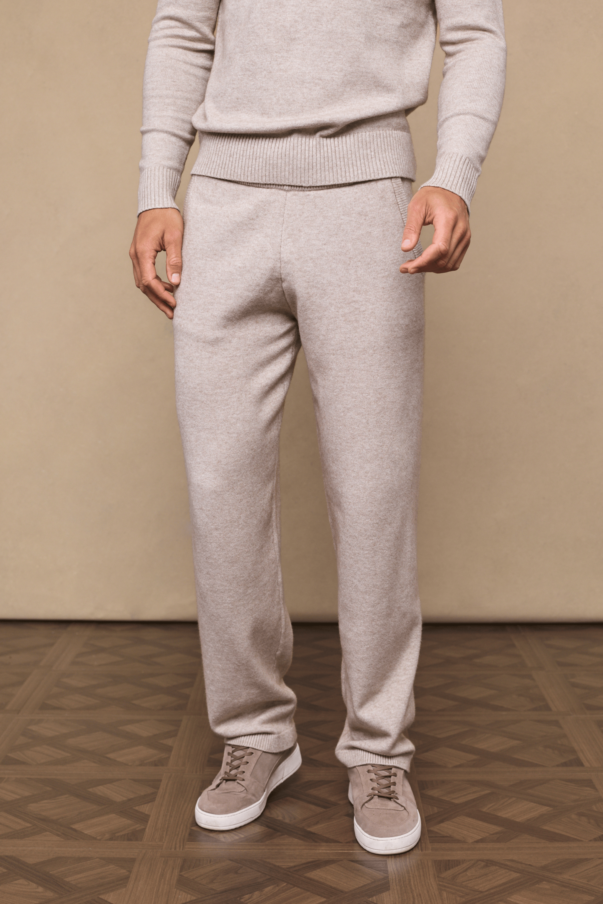 Model wearing oatmeal Rowan Knitted Trousers and matching sweater, showcasing soft fabric and side pockets.