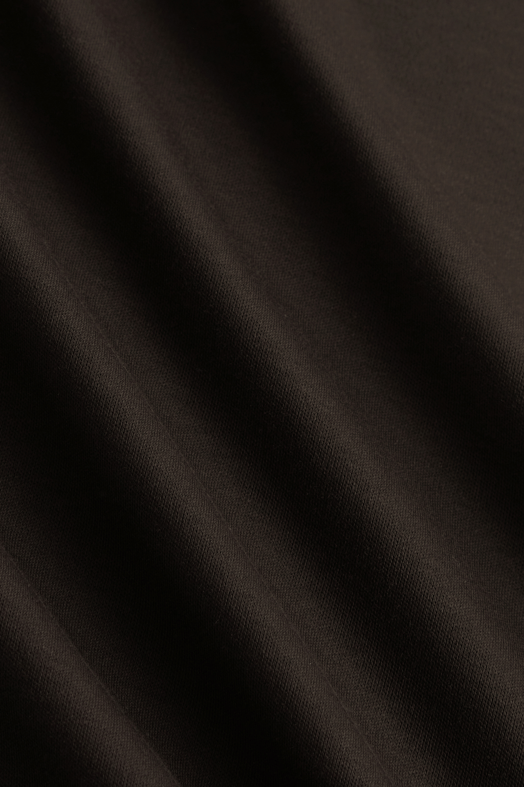 Close-up of a brown mercerised cotton fabric with subtle folds, showing its smooth, lustrous finish.