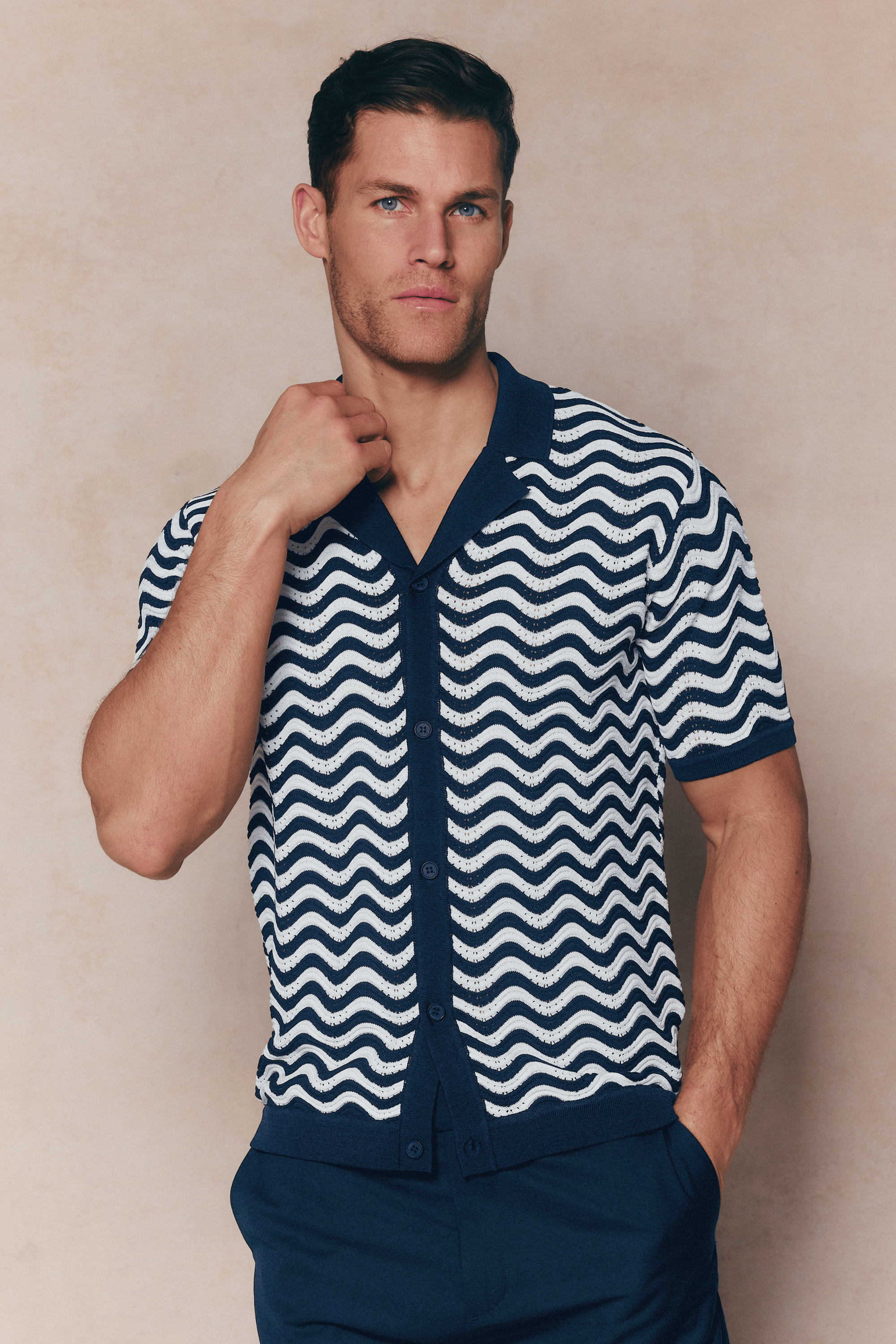 Man in Serenita Ecru/Navy knitted shirt with wavy pattern, open collar, and full button placket.