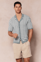 Man wearing a sage/white Serenita knitted shirt with a wave pattern, open collar, and button-through front.