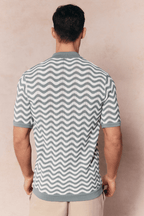 Man from behind wearing a Serenita knitted shirt in sage/white with a wave pattern and short sleeves.