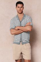 Man in Serenita sage/white knitted shirt with wave pattern, open collar, and button-through front.
