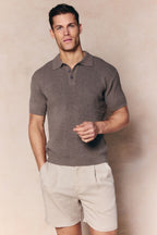 Man wearing a dark sage Sorelle short sleeve ribbed knit polo with a collar and button placket.