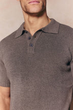 Man wearing a dark sage Sorelle short sleeve ribbed knit polo with a classic collar and button placket.